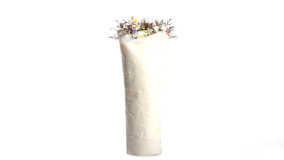 A bouquet tightly wrapped in several layers of ivory paper on a white background